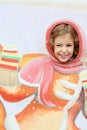 Smiling girl stucks head in plywood scenery at fair