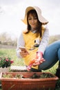 Smiling girl in sun hat holding smartphone in backyard Royalty Free Stock Photo