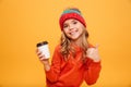 Smiling girl in sweater and hat holding cup of tea Royalty Free Stock Photo