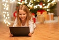 Smiling girl with tablet pc at christmas home