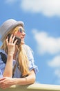 Smiling girl talking mobile phone against sky Royalty Free Stock Photo