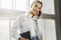 Smiling girl talking on smartphone, holding black notepad. Beautiful girl use mobile phone for work, call clients