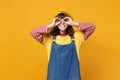 Smiling girl teenager in french beret and denim sundress holding hands near eyes, imitating glasses or binoculars Royalty Free Stock Photo