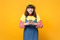 Smiling girl teenager in french beret, denim sundress using mobile phone, typing sms message isolated on yellow Royalty Free Stock Photo