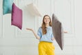 Smiling girl throwing pillows. Happy playful woman in pyjama Royalty Free Stock Photo