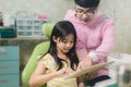 A smiling girl with thumb raised having teeth examination at dental clinic. People, medicine, stomatology and health care concept