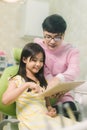 A smiling girl with thumb raised having teeth examination at dental clinic. People, medicine, stomatology and health care concept