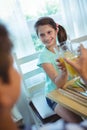 Smiling girl toasting glass of orange juice