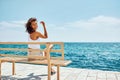 Girl traveler sitting on bench near the beach Royalty Free Stock Photo