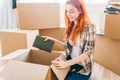 Smiling girl unpacking cardboard boxes, new home Royalty Free Stock Photo