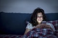 Smiling girl using smartphone in bed Royalty Free Stock Photo