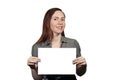 Smiling girl on a white background holds a sheet of paper with a space for writing Royalty Free Stock Photo