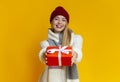 Smiling girl in winter clothes giving xmas gift Royalty Free Stock Photo