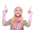 Smiling girl in winter clothes pointing up on copy space Royalty Free Stock Photo