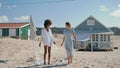 Smiling girlfriends dancing beach at seashore houses. Happy lgbt couple resting Royalty Free Stock Photo