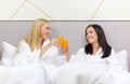 Smiling girlfriends having breakfast in bed Royalty Free Stock Photo