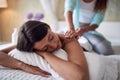 Smiling girlfriends lying on bed and girl making massage Royalty Free Stock Photo