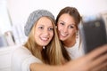 Smiling girlfriends taking selfie