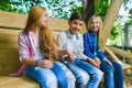 Smiling girls and boy having fun at playground. Children playing outdoors in summer. Teenagers on a swing. Royalty Free Stock Photo