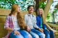 Smiling girls and boy having fun at playground. Children playing outdoors in summer. Teenagers on a swing. Royalty Free Stock Photo