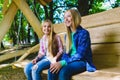 Smiling girls and boy having fun at playground. Children playing outdoors in summer. Teenagers on a swing. Royalty Free Stock Photo
