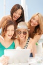 Smiling girls looking at tablet pc in cafe Royalty Free Stock Photo