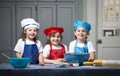 Smiling girls with mixing bowls and rolling pins