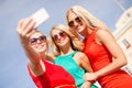 Smiling girls taking photo with smartphone camera Royalty Free Stock Photo