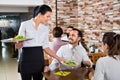 Female waiter bringing order to visitors in country restaurant Royalty Free Stock Photo