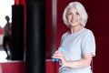 Smiling glad woman holding jumping rope.