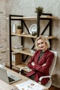 Smiling good-looking lady spending time in office armchair