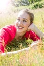 Smiling gorgeous young woman relaxing in the grass, breathing wellbeing Royalty Free Stock Photo