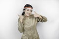 Smiling government worker woman gesturing OK sign with her thumbs up isolated by white background. PNS wearing khaki uniform.