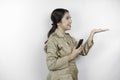 Smiling government worker woman holding her smartphone and pointing to copy space beside her. PNS wearing khaki uniform