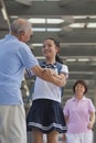 Smiling granddaughter embracing her grandfather with grandmother in background Royalty Free Stock Photo