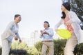 Smiling Granddaughter with grandparents playing Frisbee in the park