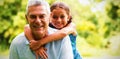 Grandfather carrying grandaughter in yard