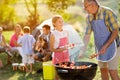 Smiling grandfather giving granddaughter grilling meat