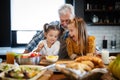 Smiling grandfather helping children to cook in the kitchen Royalty Free Stock Photo