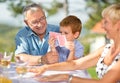 Smiling Grandfather playing cards with grandson