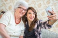 Smiling grandmother and her grandchild taking selfie photo on smart phone. Royalty Free Stock Photo