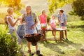 Smiling grandparents drink wine by the barbecue