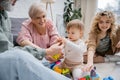 smiling grandparents giving toys to toddler