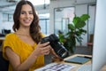 Smiling graphic designer holding digital camera in creative office Royalty Free Stock Photo