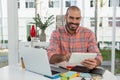 Smiling graphic designer using tablet at desk in office Royalty Free Stock Photo