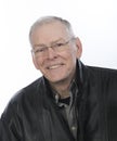 Smiling, gray haired, retiree in glasses