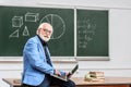 smiling grey hair professor sitting on table