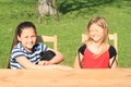 Smiling and grinning girls sitting behind the table Royalty Free Stock Photo