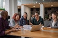 Smiling group of businesspeople laughing together in modern office work space Royalty Free Stock Photo