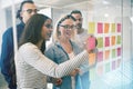 Smiling coworkers brainstorming with sticky notes in an office Royalty Free Stock Photo